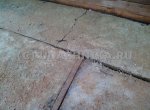 Разрушенная морозом и оттепелью бетонная плита отмостки дома